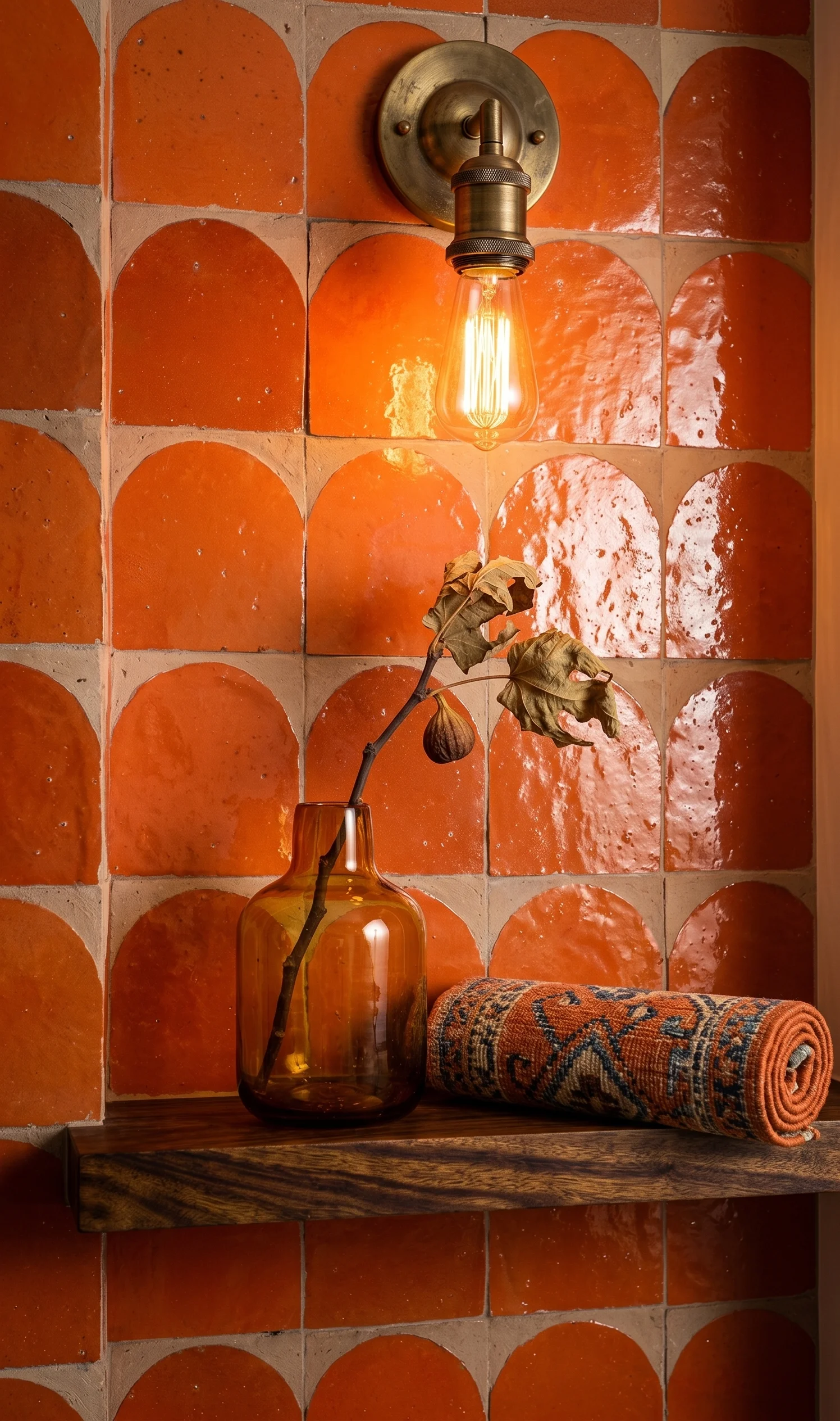 Detailshot van wandnis met oranje zellige tegels en messing wandlamp