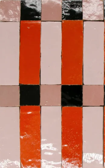 Close-up van zellige tegels in oranje, roze en zwart patroon